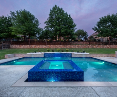 geometric pool with wall and jacuzzi.