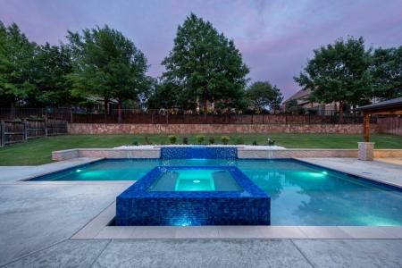geometric pool with wall and jacuzzi.