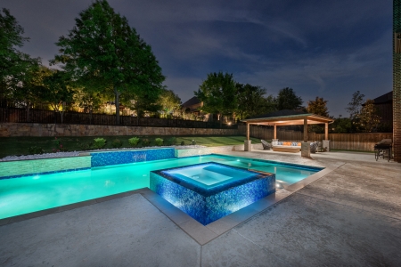 geometric pool with wall and jacuzzi.