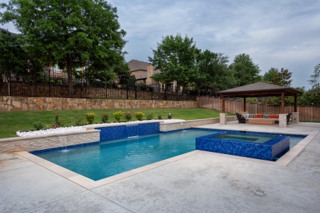 geometric pool with wall and jacuzzi.