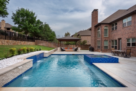 geometric pool with wall and jacuzzi.