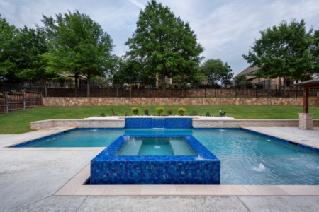 geometric pool with wall and jacuzzi.