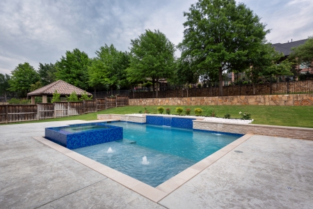 geometric pool with wall and jacuzzi.