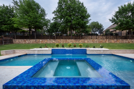 geometric pool with wall and jacuzzi.