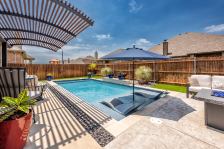 Rectangular pool with sun loungers in pool.