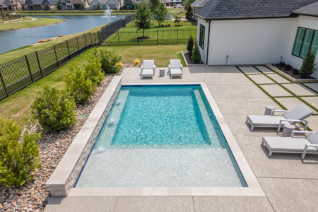geometric pool with wall and sun loungers.