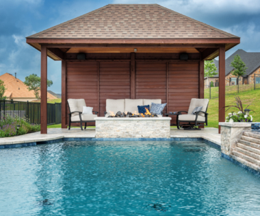 Outdoor seating area by pool with fire pit.