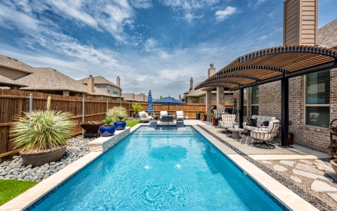 Rectangular pool with sun loungers in pool.