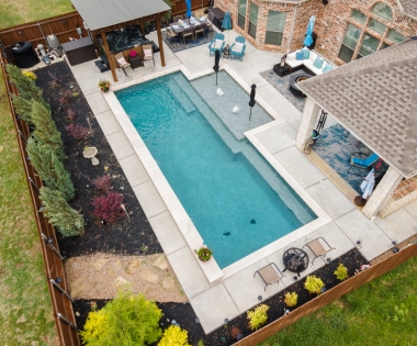 Birds eye view of geometric pool with seating.