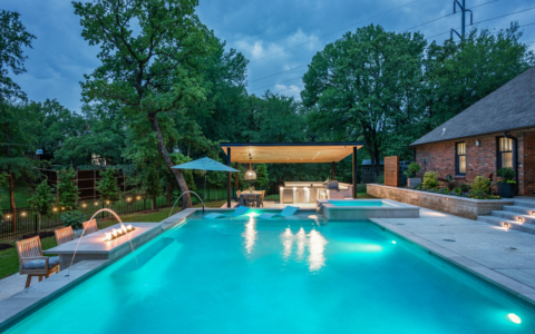 Rectangular pool at night lit up.