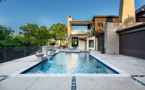 Custom pool with water flowing into pool.
